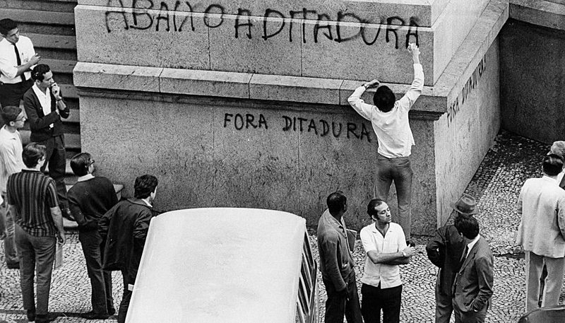 Jovem picha a fachada do Teatro Municipal do Rio durante a passeata de 1968