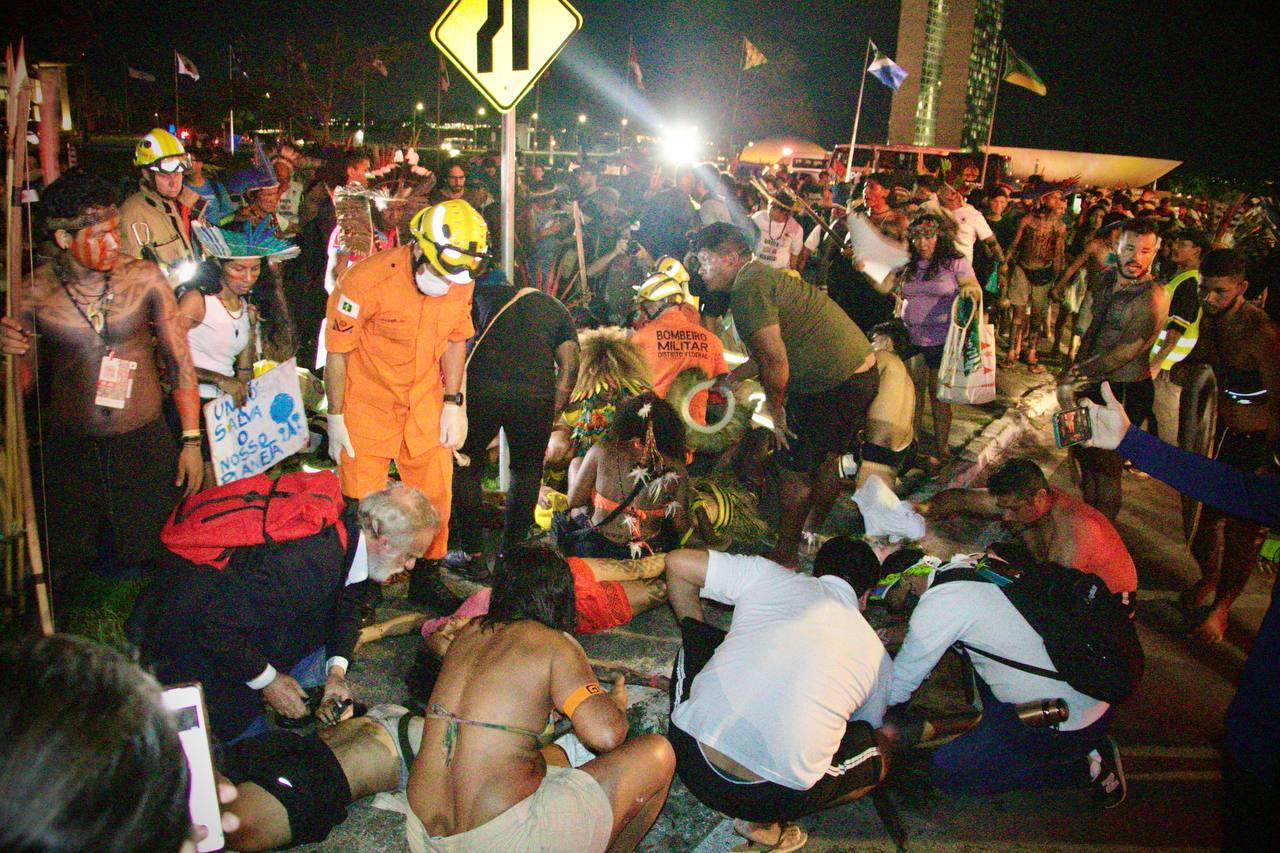 Indígenas recebem atendimento médico no gramado próximo ao Congresso após repressão policial contra marcha realizada nesta quinta-feira (10), no 21º Acampamento Terra Livre (ATL)