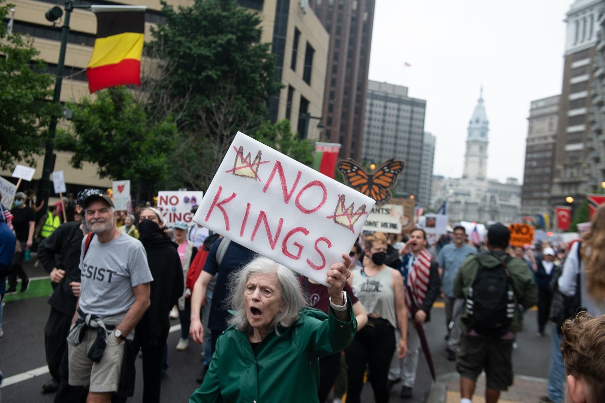 Manifestante segura um cartaz durante o protesto nacional "No Kings" (Sem Reis), na Filadélfia, Pensilvânia, em 14 de junho de 2025, no mesmo dia do desfile militar do presidente Donald Trump em Washington, D.C.