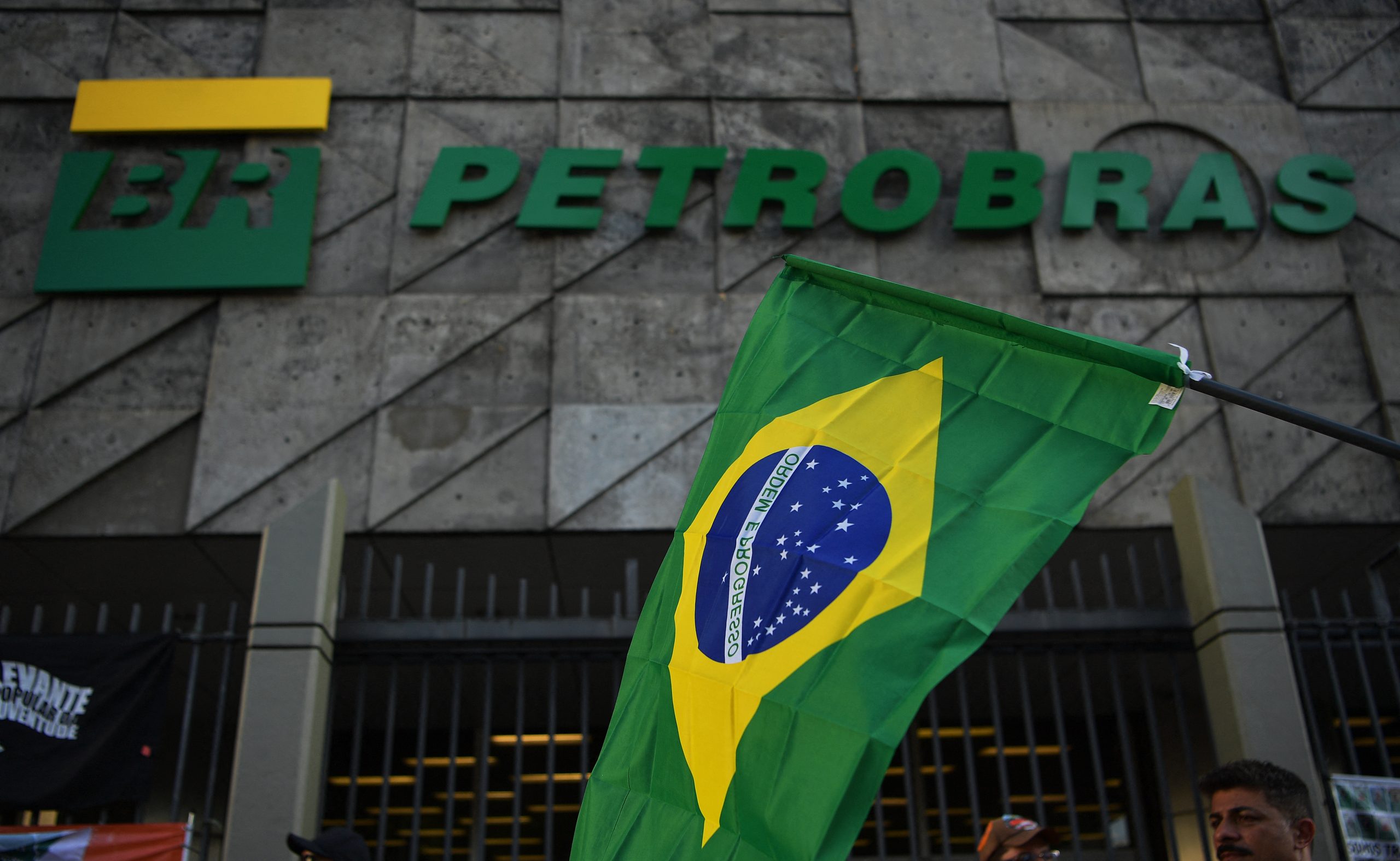 bandeira do brasil e a fachada da sede da Petrobras no Rio de Janeiro