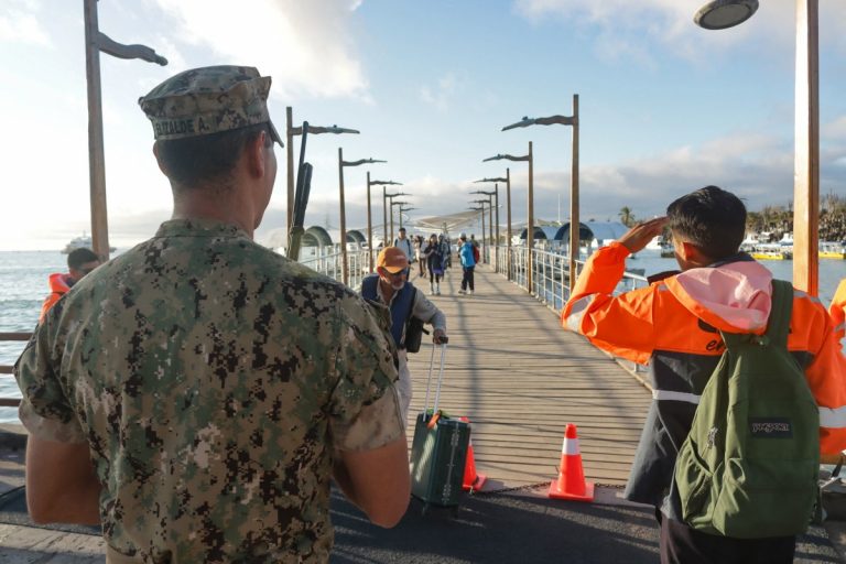 Militares da Marinha do Equador recebem turistas que estavam a bordo de barcos e foram evacuados devido ao alerta de tsunami em Puerto Ayora, Ilha de Santa Cruz, Galápagos.