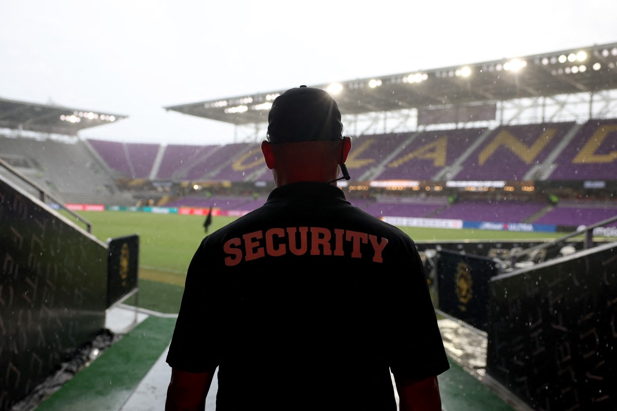 Um membro da equipe de segurança observa o campo durante um atraso devido à forte chuva durante a partida do Grupo C da Copa do Mundo de Clubes da FIFA 2025 entre SL Benfica e Auckland City FC no Estádio Inter&Co em 20 de junho de 2025 em Orlando, Flórida
