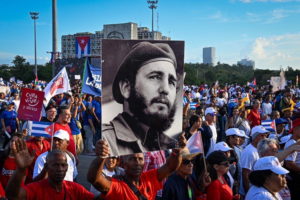 Uma mulher segura um cartaz com a imagem do falecido líder cubano Fidel Castro durante a comemoração do Dia do Trabalhador, em 1º de maio de 2025, na Praça da Revolução, em Havana