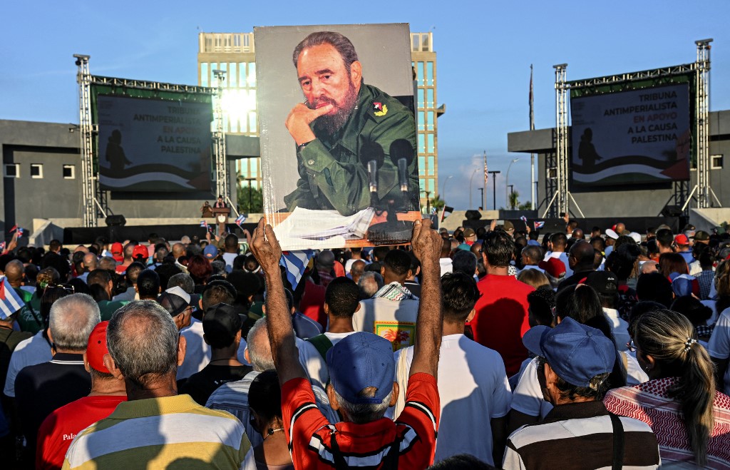 Um homem segura uma imagem do falecido líder cubano Fidel Castro durante uma manifestação em apoio ao povo palestino em frente à Embaixada dos Estados Unidos em Havana.