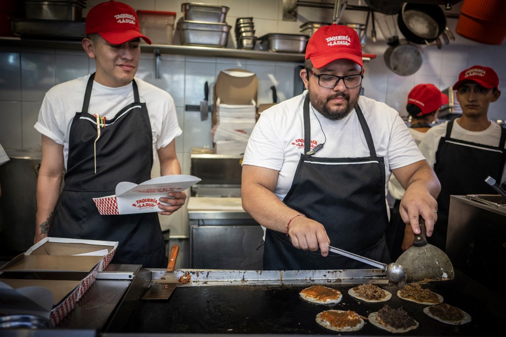 Trabalhadores preparam tacos durante a inauguração da taqueria temporária “Taqueria La Dua”, em referência à cantora e compositora britânico-albanesa Dua Lipa, na Cidade do México, em 1º de dezembro de 2025.