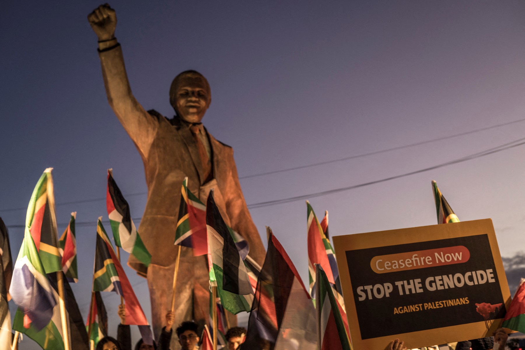 Palestinos junto a estátua de Nelson Mandela em Ramallah celebram denúncia de genocídio contra Israel feita pela África do Sul