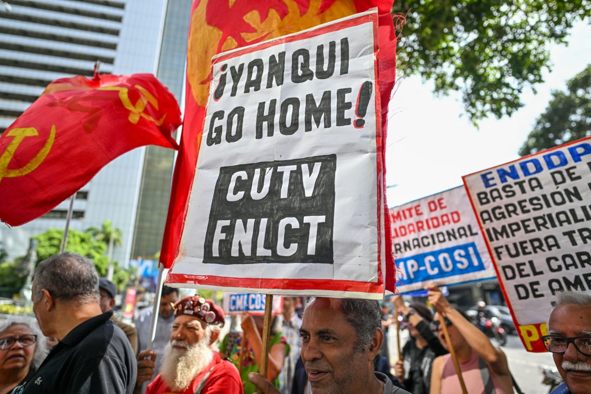 A member of the unions CUTV (Venezuelan Workers' Central Union) and FNLCT (National Front of the Working Class Struggle) holds a banner reading Yanqui go home during a protest in front of United Nations offices, rejecting actions taken by US President Donald Trump against Venezuela, in Caracas on December 19, 2025. (Photo by)