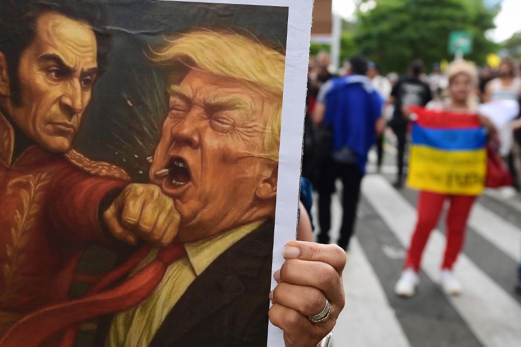 Um cartaz mostrando o herói da independência da Colômbia e da Venezuela, Simón Bolívar, socando o presidente dos Estados Unidos, Donald Trump, é exibido durante a Marcha pela Soberania e Democracia em Medellín, Colômbia, em 7 de janeiro de 2026.