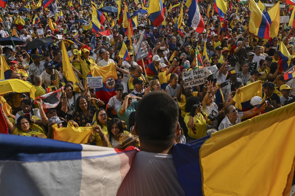 Pessoas seguram bandeiras da Colômbia durante a Marcha pela Soberania e Democracia contra as ameaças do presidente dos Estados Unidos, Donald Trump, ao presidente da Colômbia, Gustavo Petro, em Cali, Colômbia, em 7 de janeiro de 2026.