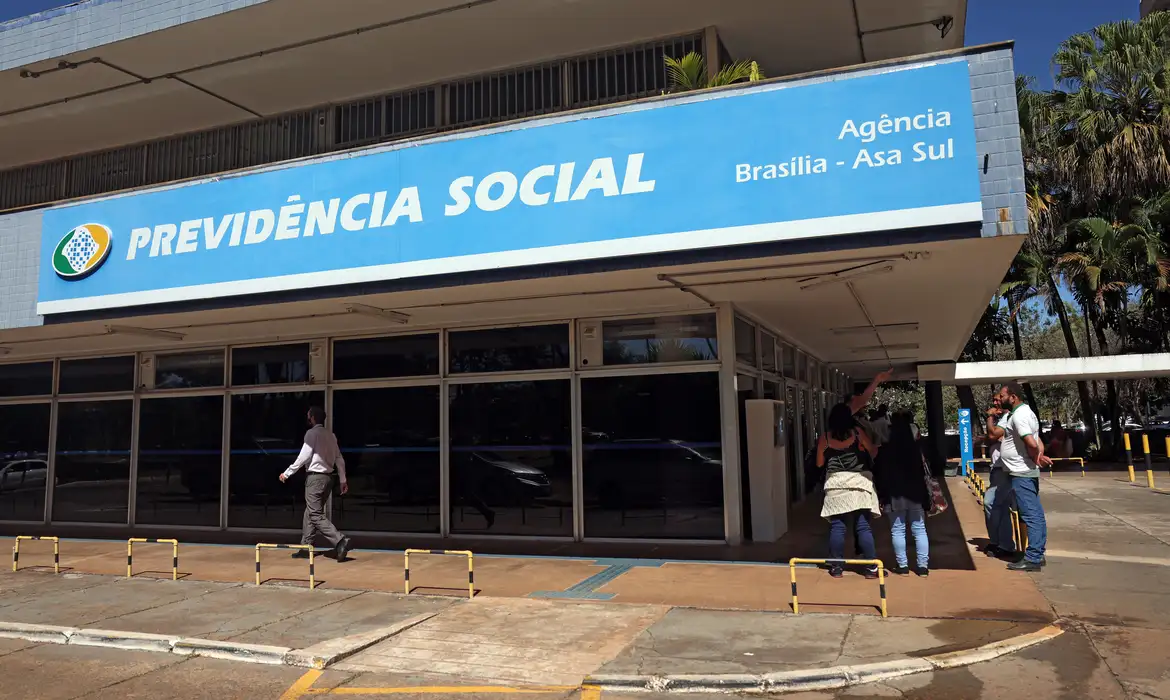 Pessoas em frente a entrada da recepção da Previdência Social. Foto: José Cruz/Agência Brasil© José Cruz/Agência Brasil