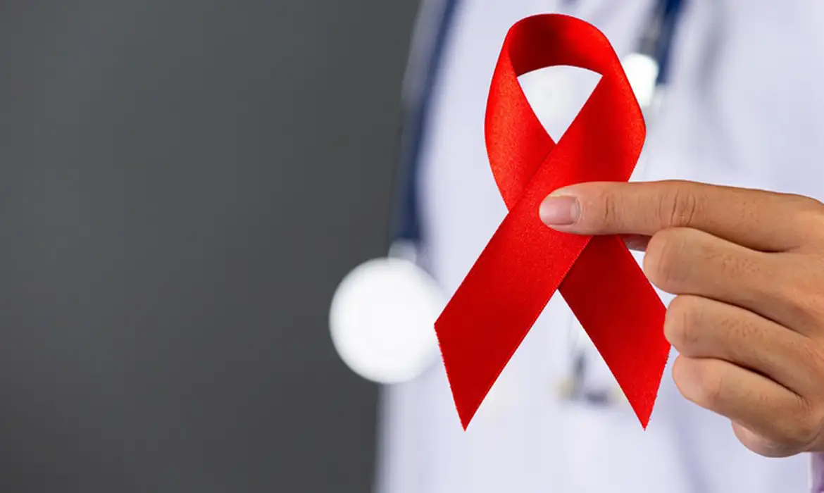 A fita vermelha (ou laço vermelho) é o símbolo universal da conscientização, apoio e solidariedade às pessoas que vivem com HIV/AIDS. Foto: MS/Divulgação© MS/Divulgação Versão em áudio