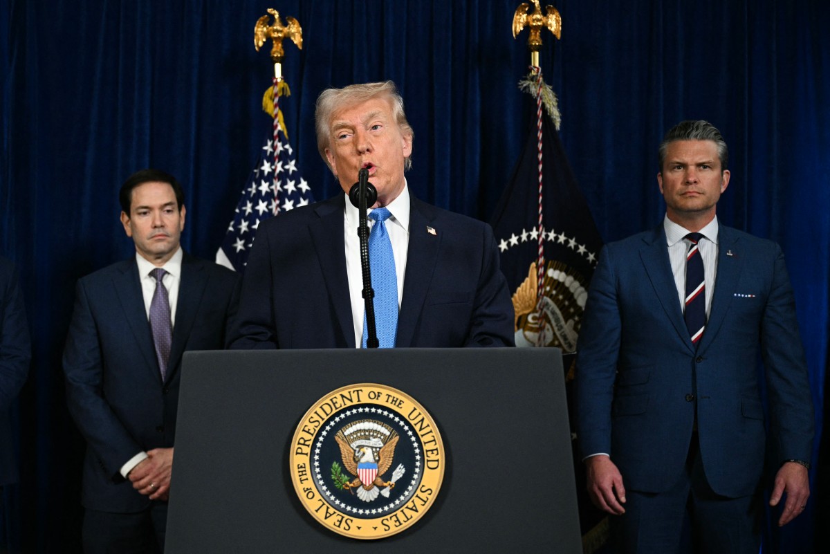 O presidente dos EUA, Donald Trump, ao lado do secretário de Estado Marco Rubio (à esquerda) e do secretário de Defesa dos EUA, Pete Hegseth (à direita), fala à imprensa após ataques dos EUA à Venezuela, em sua residência Mar-a-Lago em Palm Beach, Flórida, em 3 de janeiro de 2026.