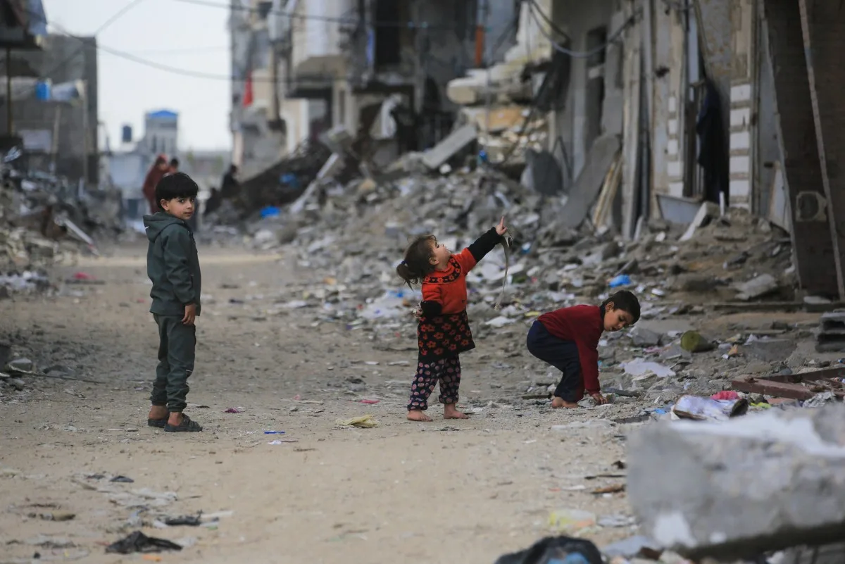 Crianças palestinas em meio a destroços de sua terra