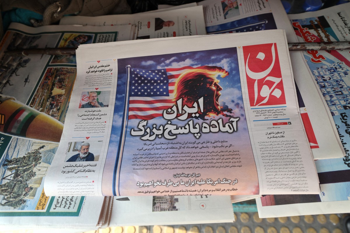 A photograph shows a newspaper with a headline in Persian reading Iran is ready for a big response at a kiosk in Tehran on January 27, 2026. A US naval strike group led by an aircraft carrier has deployed to Middle Eastern waters, the United States said on January 26, 2026, as Tehran warned it was ready to hit back at any American attack launched in response to a crackdown on anti-government protests. (Photo by ATTA KENARE / AFP)