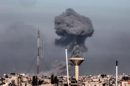 Foto tirada em Rafah mostra fumaça subindo sobre os edifícios em Khan Yunis em ataque israelense em 2024