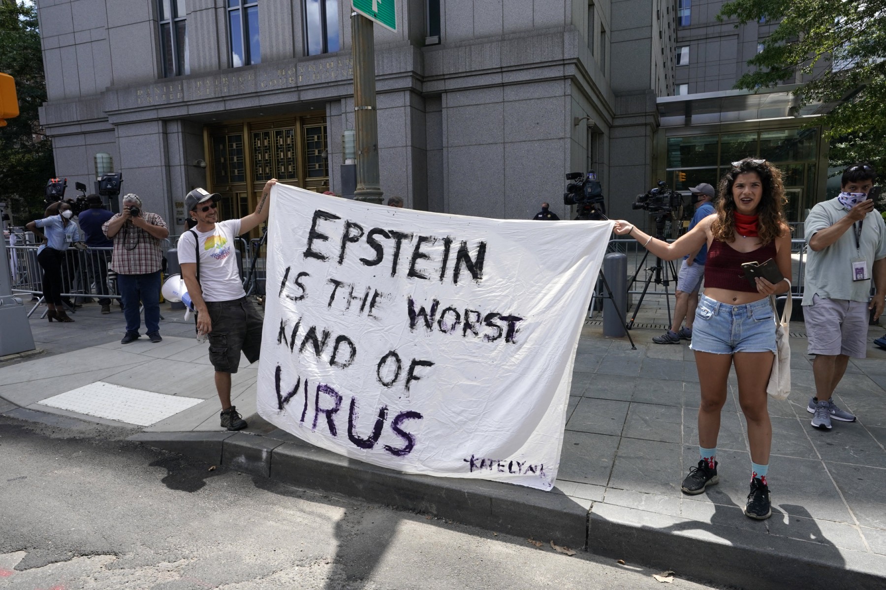 Faixa com frase em inglês diz: "Epstein é o pior tipo de vírus"