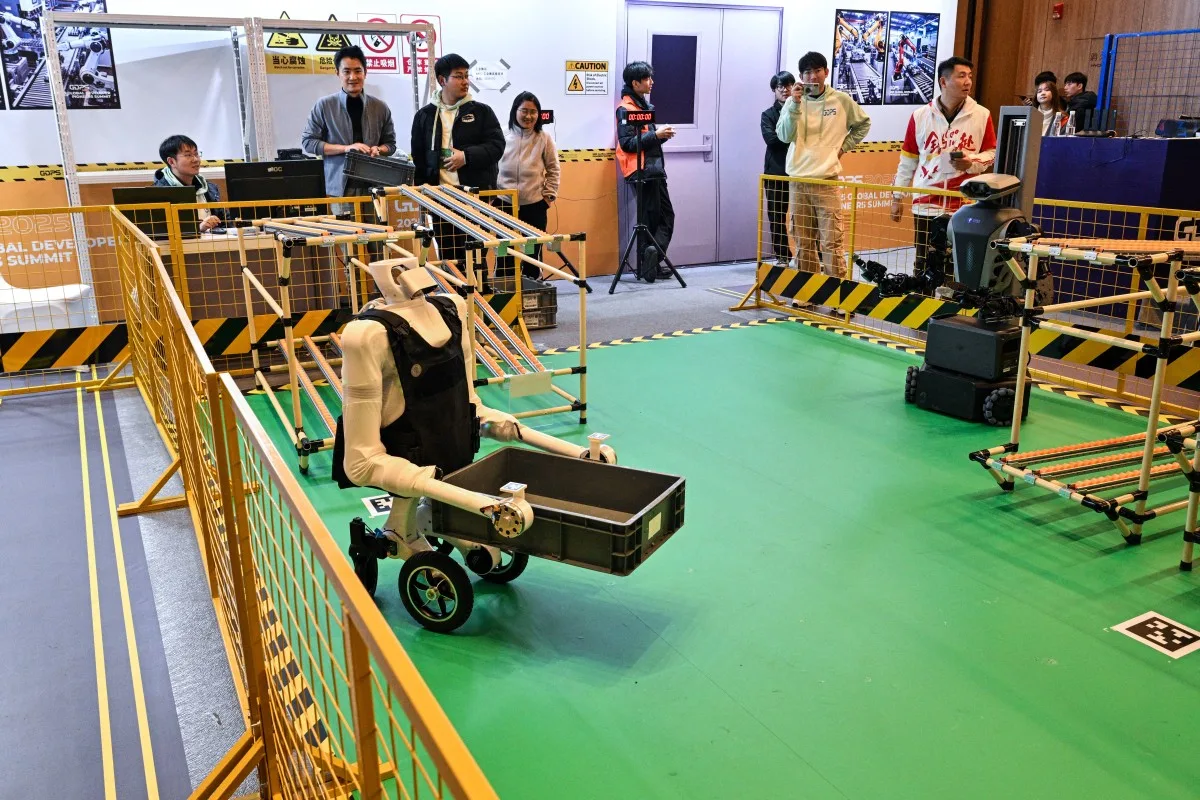 Um robô controlado remotamente é visto durante uma competição de robôs na Cúpula Global de Pioneiros Desenvolvedores de 2025 em Xangai, em 12 de dezembro de 2025. (Foto de Hector RETAMAL / AFP)