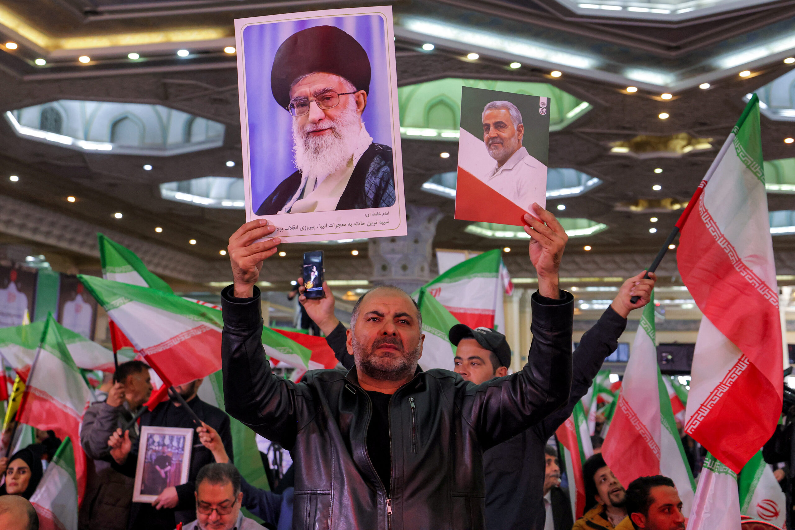 Homem segura uma foto do Líder Supremo do Irã, o Aiatolá Ali Khamenei, e outra do comandante da Guarda Revolucionária Islâmica (IRGC), Qasem Soleimani, assassinado em um ataque dos EUA em Bagdá (Iraque), em 3 de janeiro de 2020.