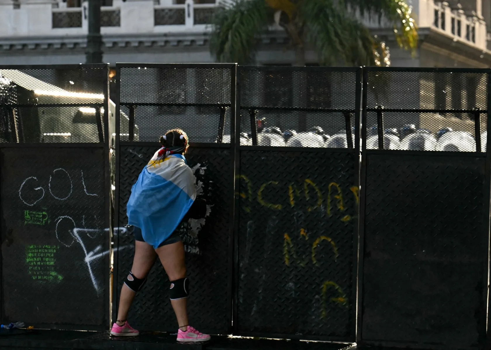 Manifestante em frente a barricada policial em Buenos Aires antes da votação na Câmara