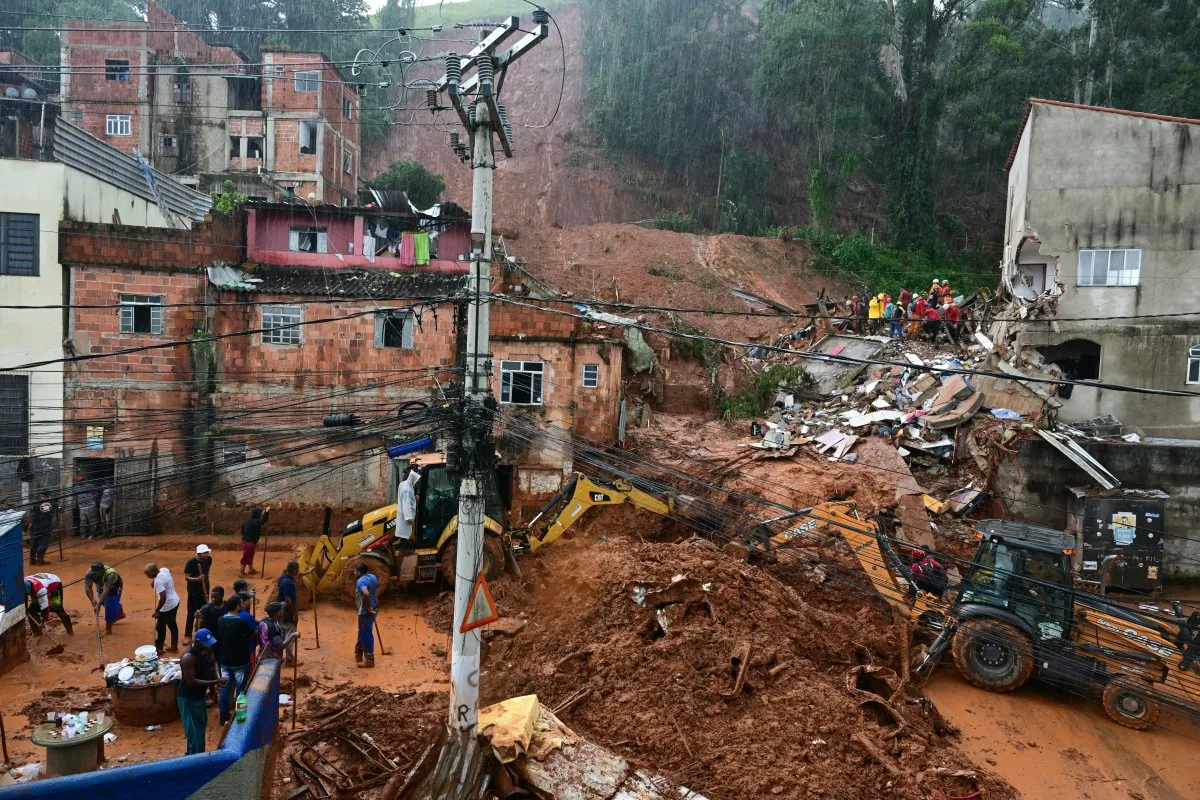 Equipes de resgate removem destroços em busca de vítimas de um deslizamento de terra causado por fortes chuvas no bairro Parque Jardim Burnier, em Juiz de Fora (MG)