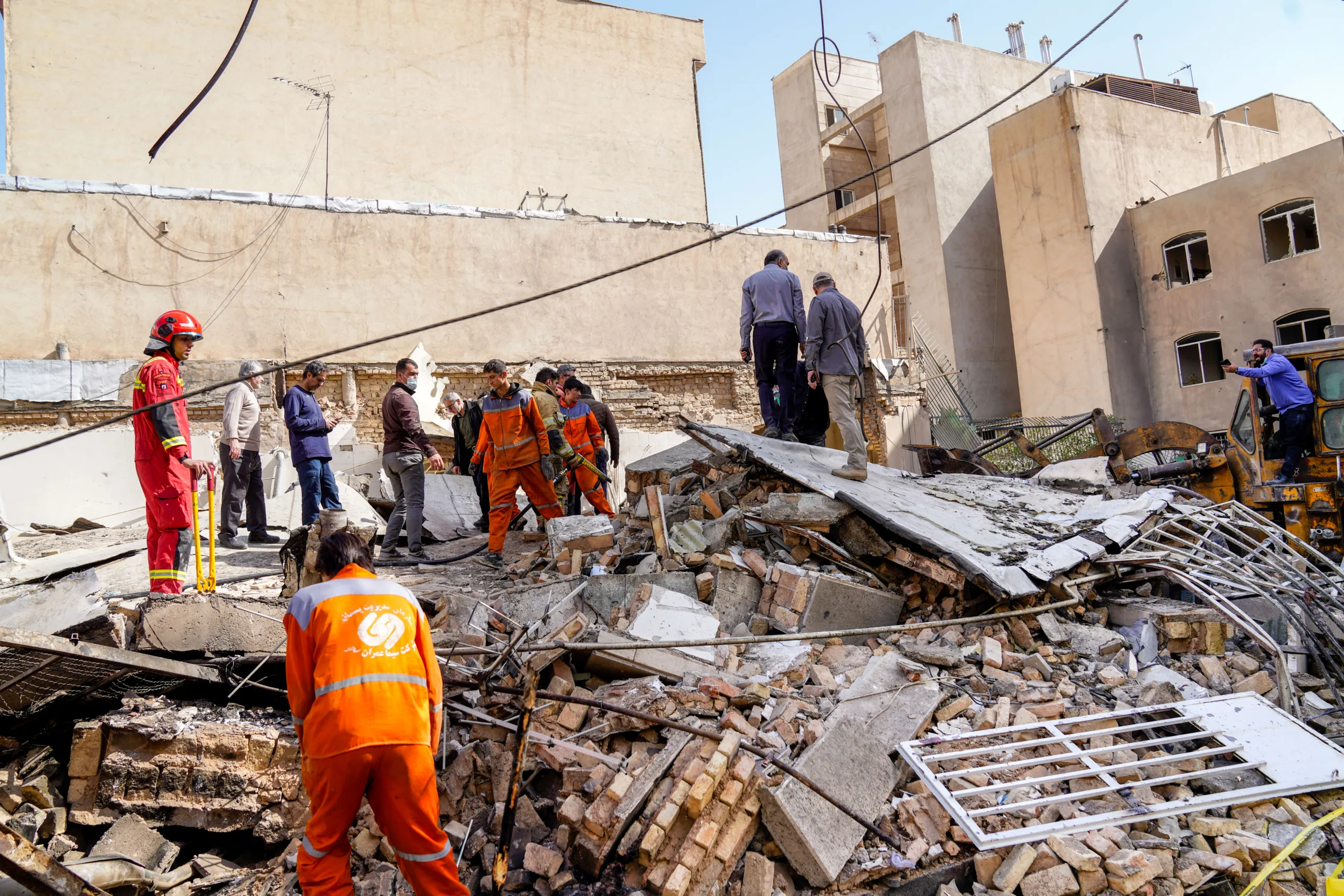 Equipes de resgate vasculham os escombros de um prédio que desabou no local onde um míssil atingiu um bairro, em Teerã, no Irã