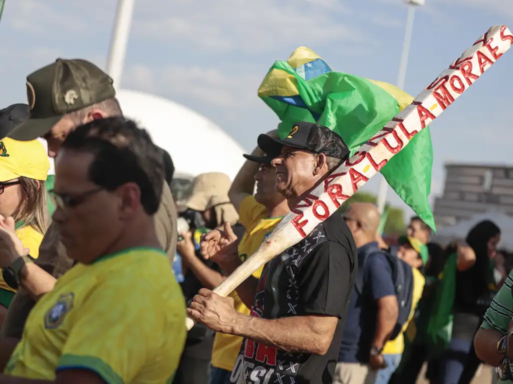 Manifestante de extrema-direita carrega um “porrete” no qual se lê “Fora Lula Moraes”