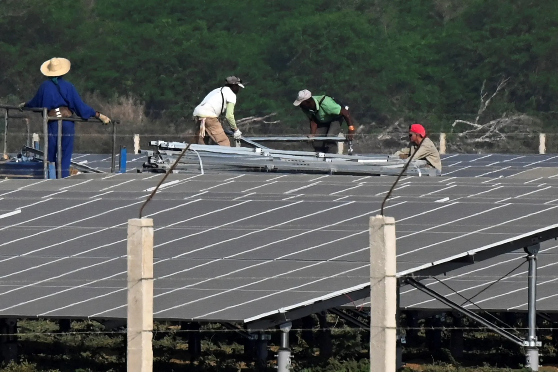 funcionários trabalham na montagem do parque solar fotovoltaico La Yuca, na província de Cienfuegos, Cuba. 