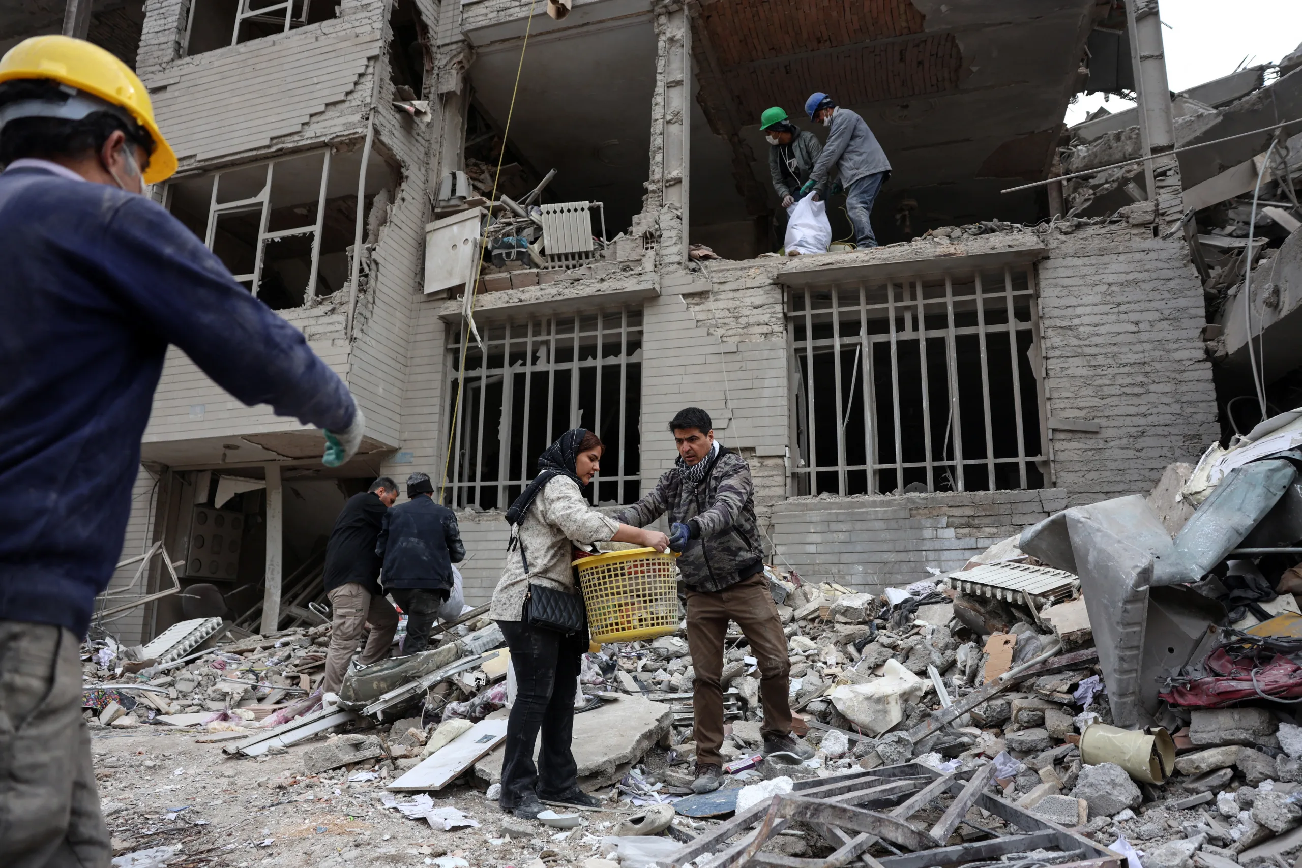 Iranianos recolhem seus pertences dos escombros de um prédio residencial impactado pelos ataques de EUA e Israel em Teerã - 12 de março de 2026