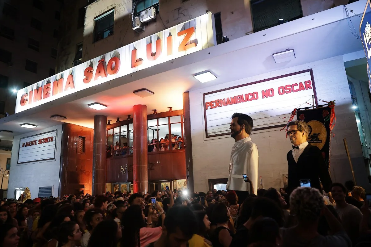 Bonecos gigantes do diretor Kleber Mendonça Filho e do ator Wagner Moura, de O Agente Secreto, em frente ao cinema São Luiz, no Recife, na expectativa pelo resultado do Oscar 2026, neste domingo (15)