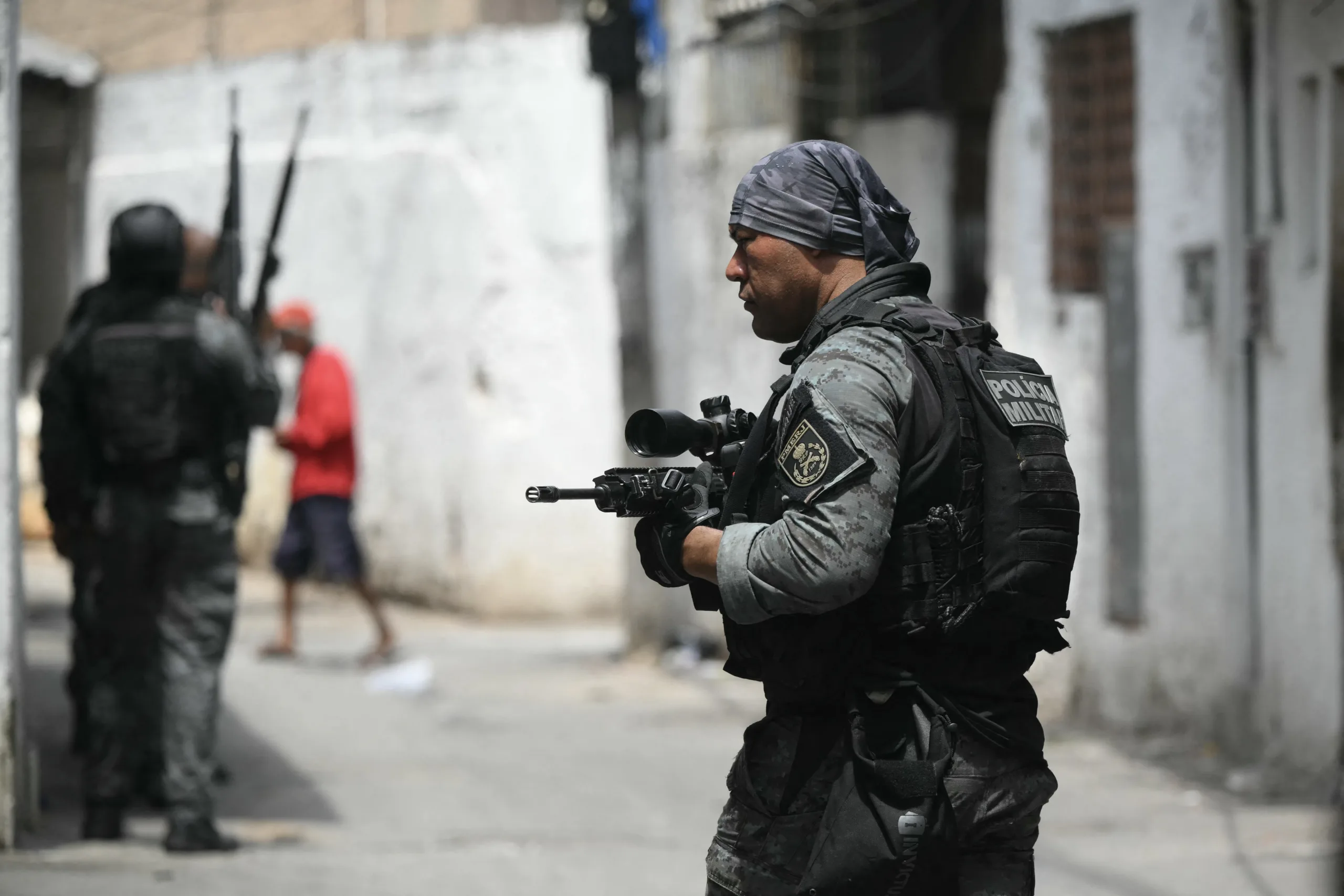 Militariy police officers patrol during the Operacao Contencao (Operation Containment) at the Vila Cruzeiro favela, in the Penha complex, in Rio de Janeiro, Brazil, on October 28, 2025. At least 2,500 security forces agents took part in an operation to arrest drug traffickers from the Comando Vermelho (CV), which resulted in 18 suspects and several police officers dead. (Photo by Mauro PIMENTEL / AFP)