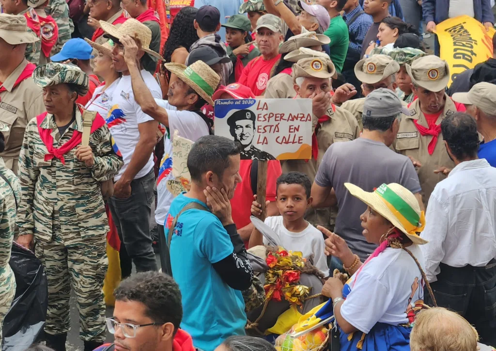 Criança segura um cartaz com a imagem de Hugo Chávez e os dizeres: "A esperança está nas ruas"