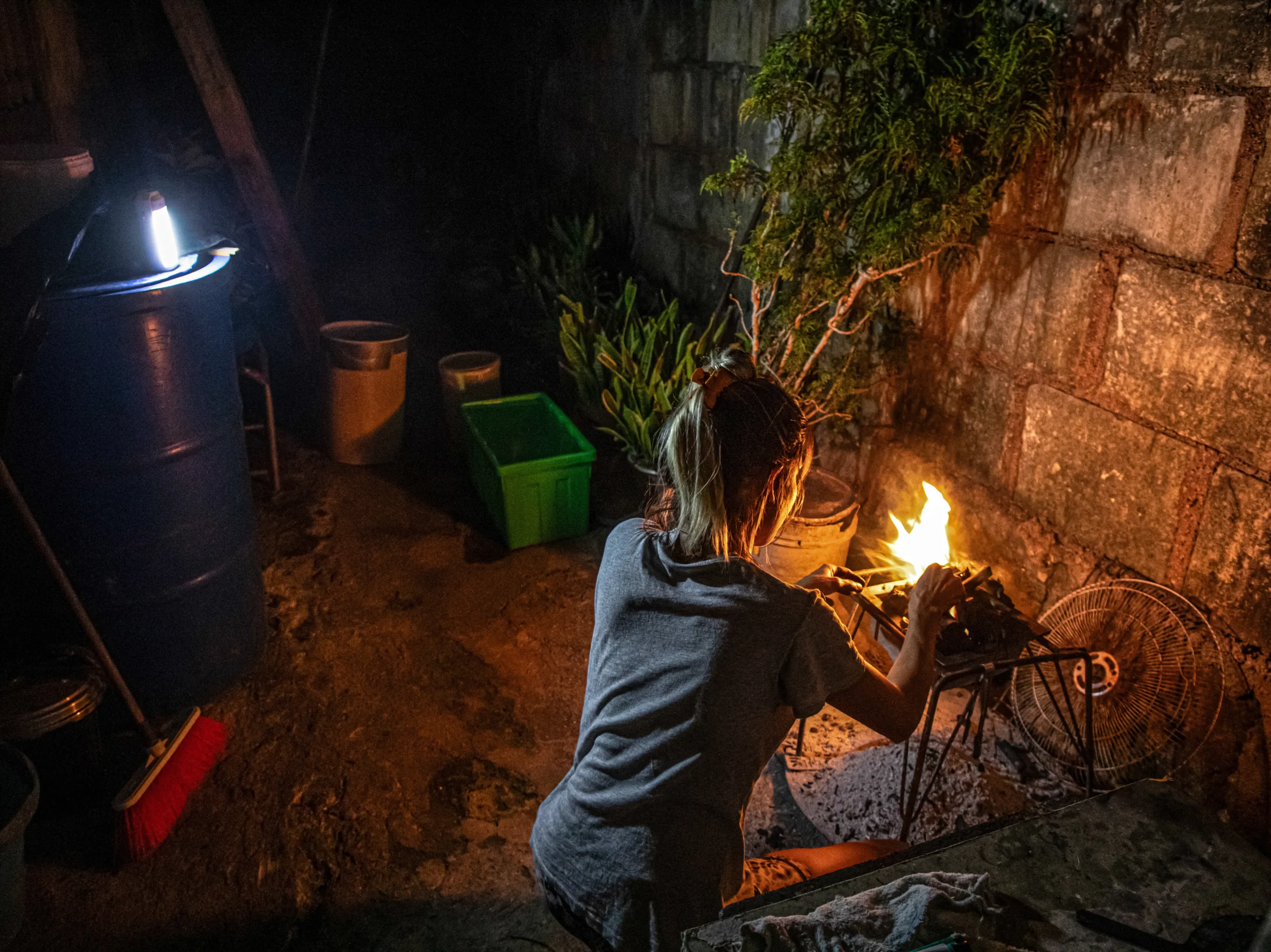 Mulher usa lenha para cozinhar durante apagão em Matanzas, no dia 6 de abril