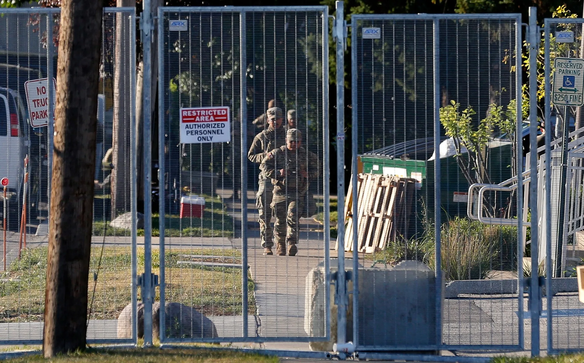 Membros da Guarda Nacional do Texas caminham pelo interior do perímetro de uma instalação de detenção do Serviço de Imigração e Controle de Fronteiras dos EUA (ICE) em Broadview, Illinois, em 8 de outubro de 2025