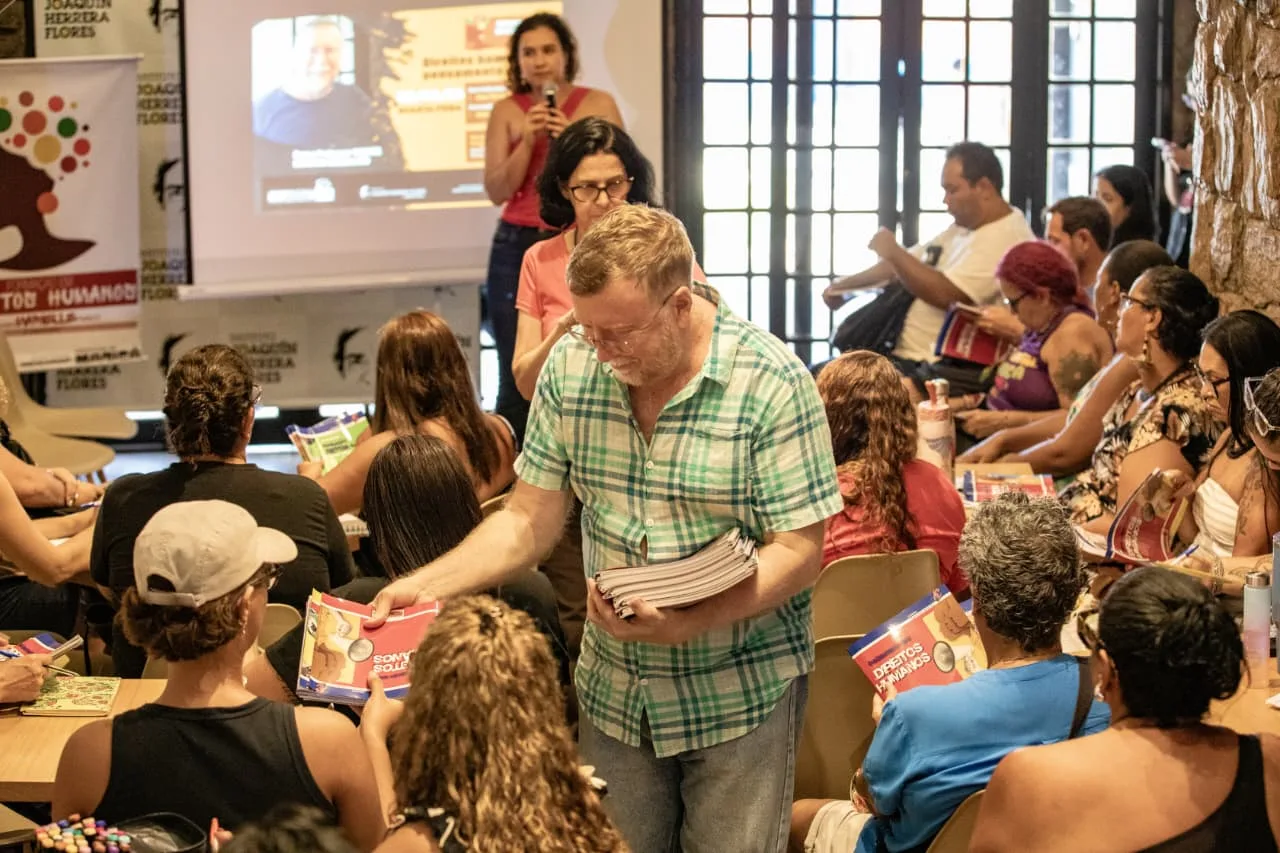 Professores distribuem material didático aos alunos participantes do curso