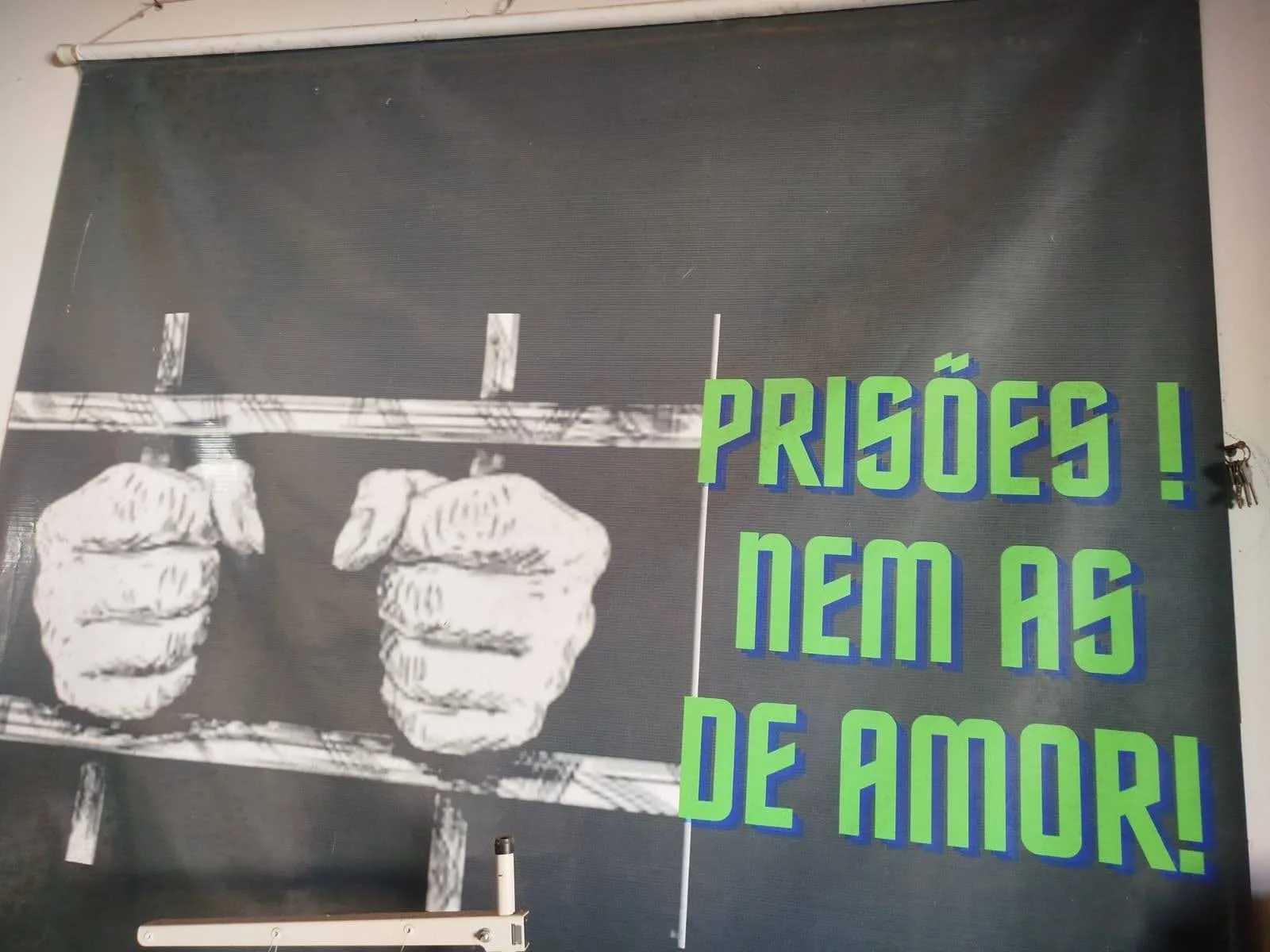 Banner ‘Prisões! Nem as de amor!’ pendurado na parede da sede do Coletivo Mulheres Arteiras