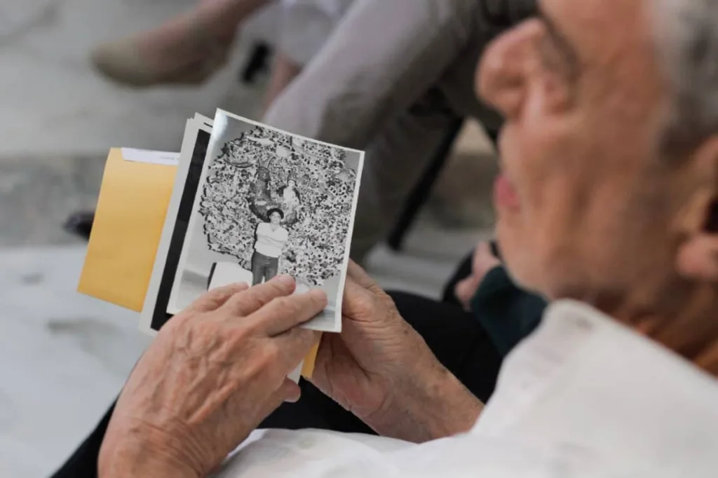 Chico sostiene una vieja foto de Silvio.
