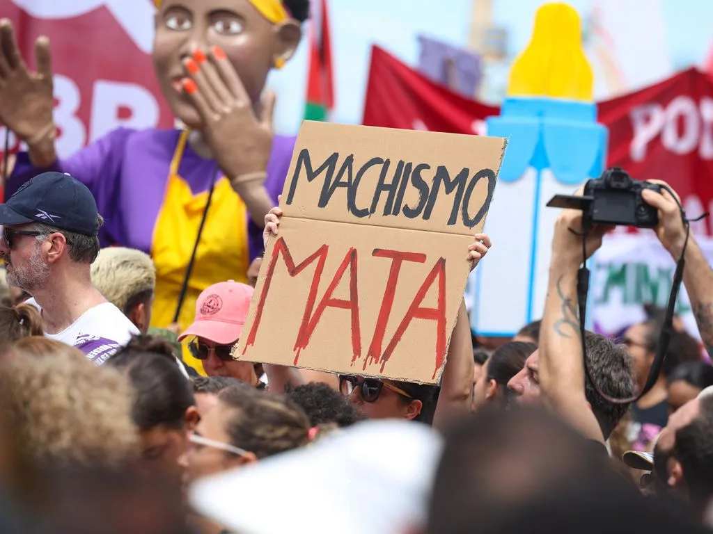 Manifestante segura cartaz feito em papelão onde se lê "machismo mata"