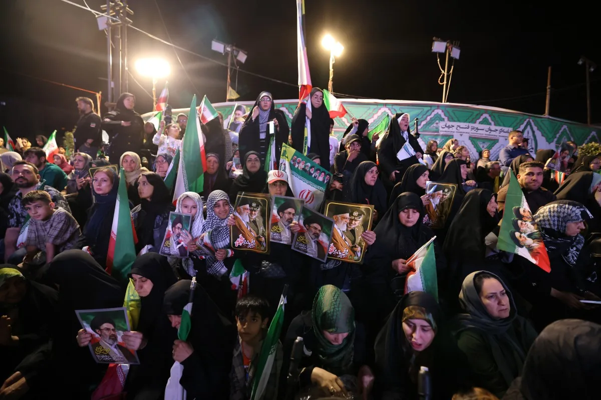 Pessoas seguram retratos do líder supremo do Irã, o aiatolá Mojtaba Khamenei, durante a cerimônia de despedida da seleção iraniana de futebol, antes de sua partida para a Copa do Mundo da FIFA de 2026, em Teerã, em 13 de maio de 2026.