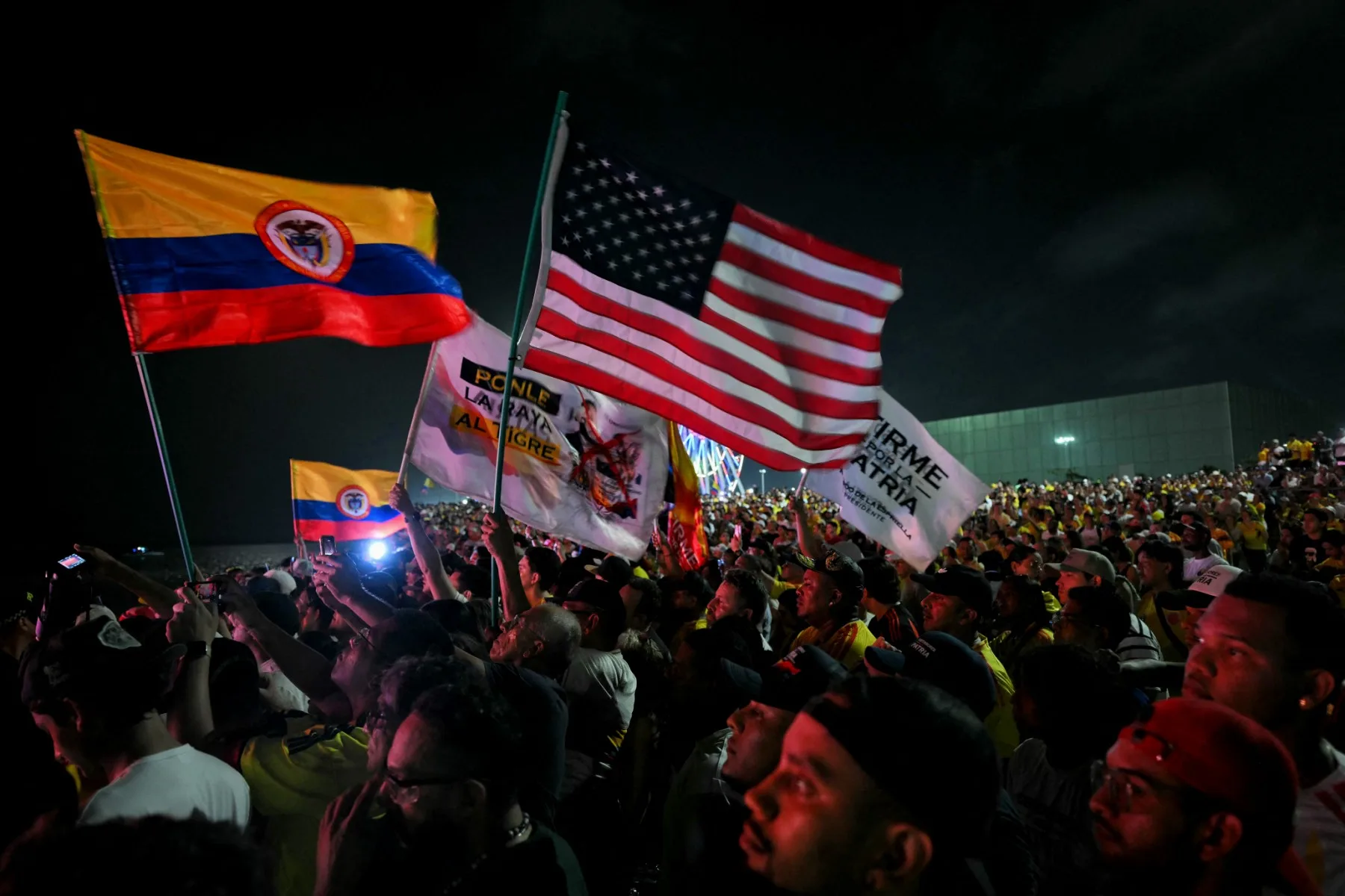 Supporters of Colombia's presidential candidate Abelardo de la Espriella, of the Salvadores de la Patria movement, gather holding Colombian flags and a US flag to listen to the candidate after a quick count of votes in the presidential election at the Ventana al Mundo monument in Barranquilla, Colombia, on May 31, 2026. Colombia's presidential election appeared headed for a runoff between leftist Ivan Cepeda and hard-right Abelardo de la Espriella on May 31, presenting voters with a stark choice between peace talks and a militarized crackdown. (Photo by Rodrigo BUENDIA / AFP)