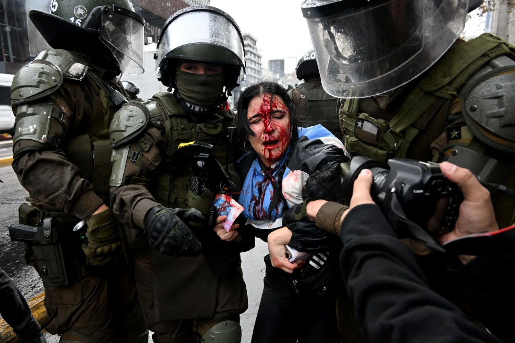Policiais de choque prendem um manifestante durante uma marcha estudantil contra os cortes sociais implementados pelo presidente do Chile