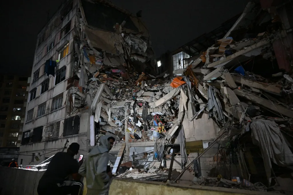 Pessoas observam um prédio desabado no bairro de Altamira após um terremoto em Caracas, em 24 de junho de 2026