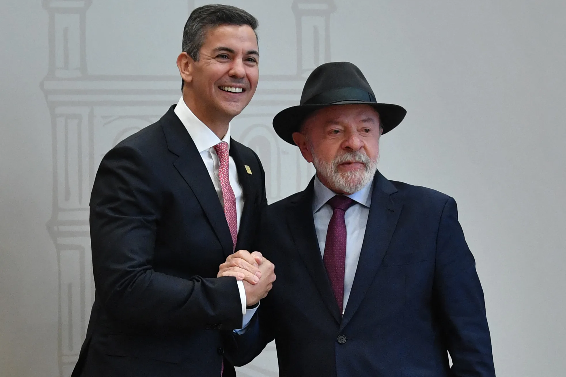 O presidente do Brasil, Luiz Inácio Lula da Silva (à direita), cumprimenta com um aperto de mãos o presidente do Paraguai, Santiago Peña, à sua chegada para a 68ª Cúpula de Chefes de Estado do Mercosul, na sede da Conmebol, em Luque, Paraguai, em 30 de junho de 2026