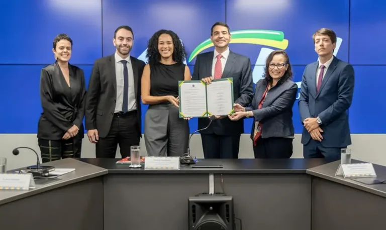 A servidora Flávia Henriques Goes de Medeiros (ao centro da foto) durante assinatura de acordo com a Advocacia-Geral da União (AGU)