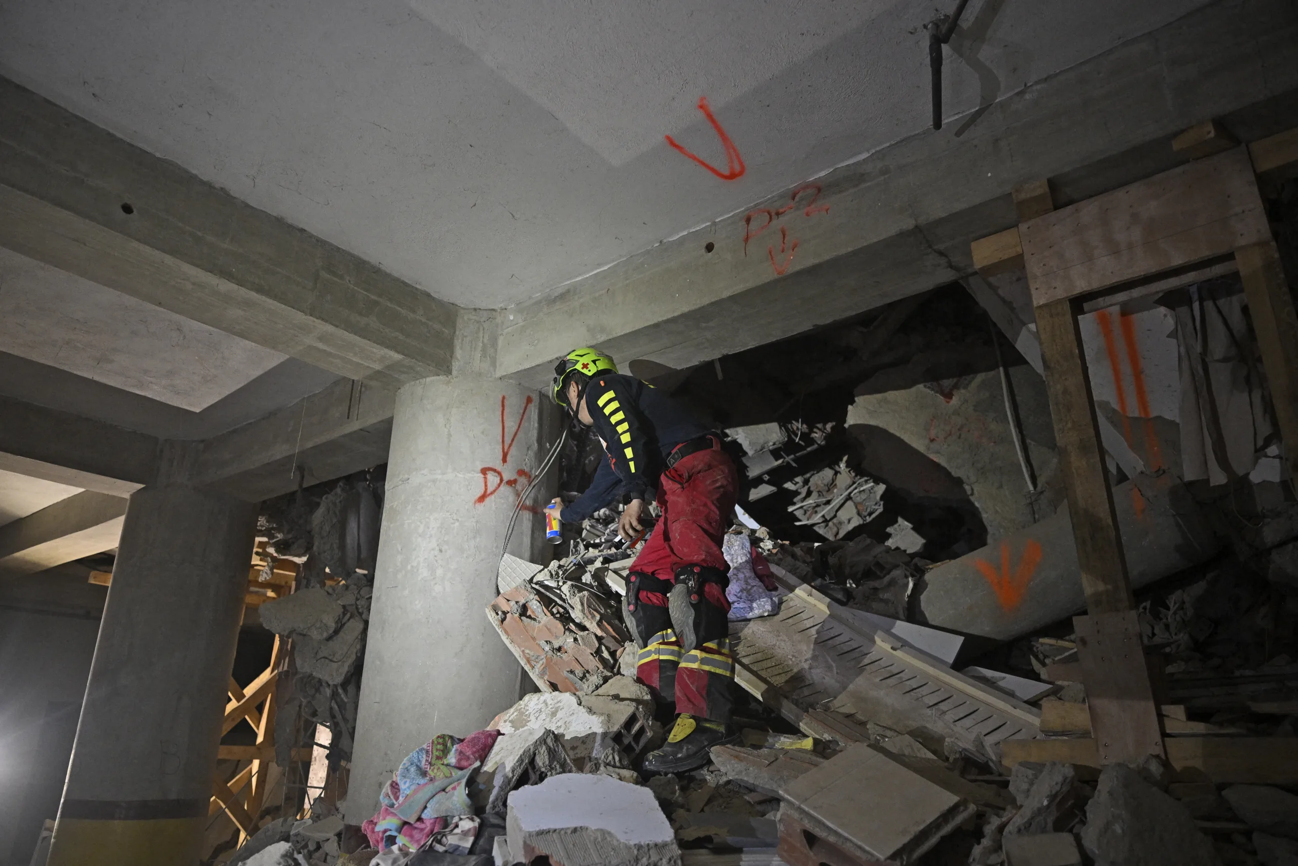 Um socorrista dos EUA marca uma parede com a letra "V" de vítimas na garagem do edifício de onde Hernan Gil foi resgatado em Catia La Mar, no Estado de La Guaira, Venezuela, em 2 de julho de 2026, oito dias após terremotos.