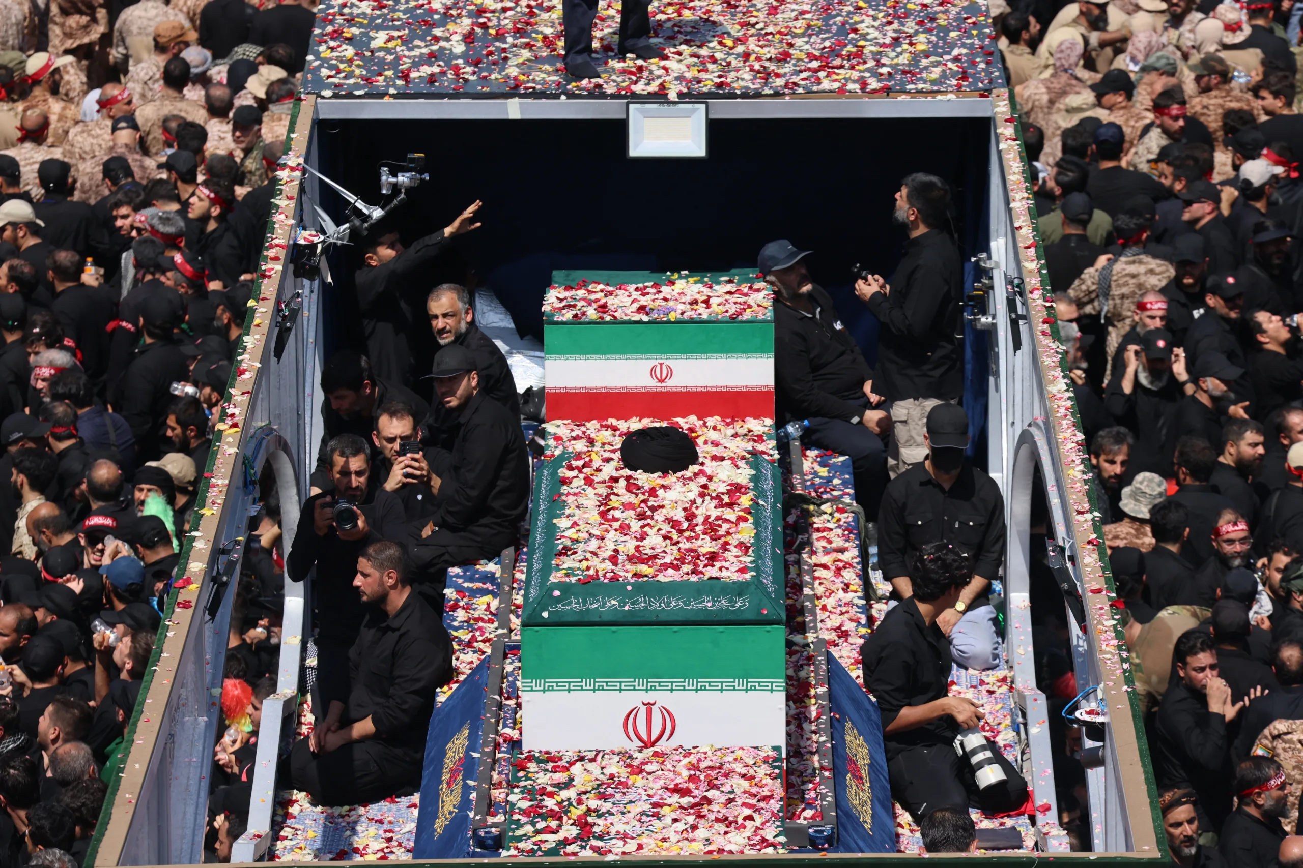 People gather along a street during the funeral procession of Iran's slain Supreme Leader Ali Khamenei and his family members in Tehran July 6, 2026. The funeral procession for Iran's late supreme leader Ali Khamenei began in Tehran on July 6, state television reported, as authorities prepared for crowds that could rival those that turned out for his predecessor nearly four decades ago. (Photo by ) /