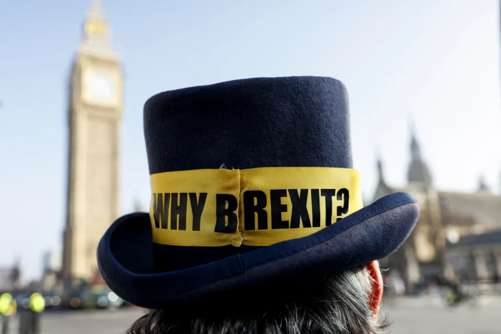 Um chapéu masculino onde se lê 'Por que o Brexit' é fotografado durante uma pequena manifestação anti-Brexit na Parliament Square, em Londres, em 4 de março de 2026.