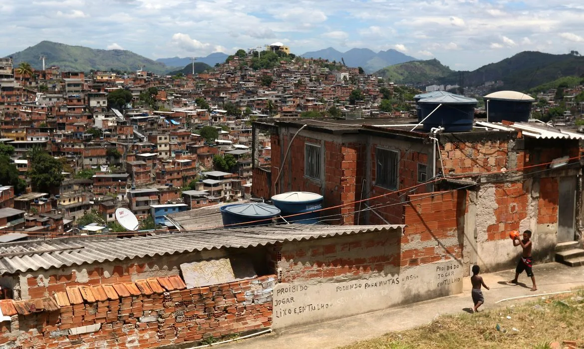 Fotografia de uma casas sem reboco em uma favela