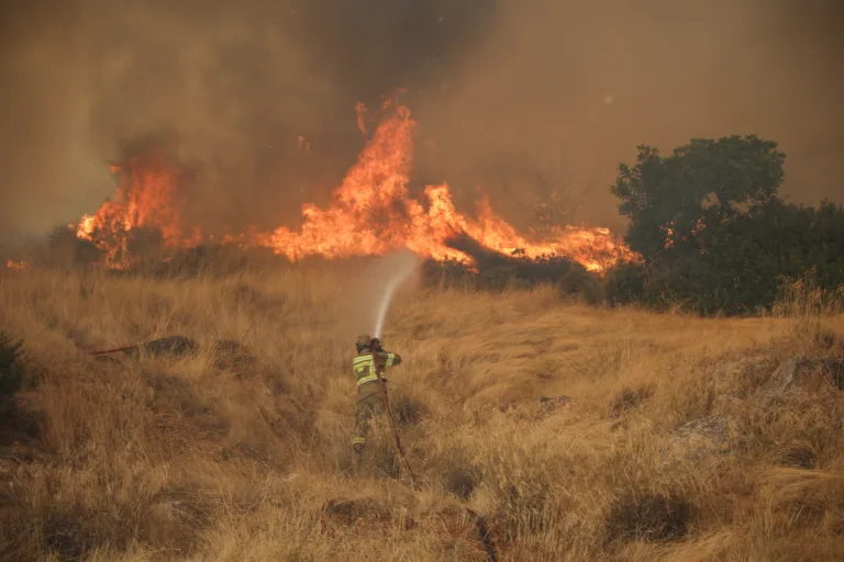 Bombeiro tenta conter chamas de incêndio na Grécia.