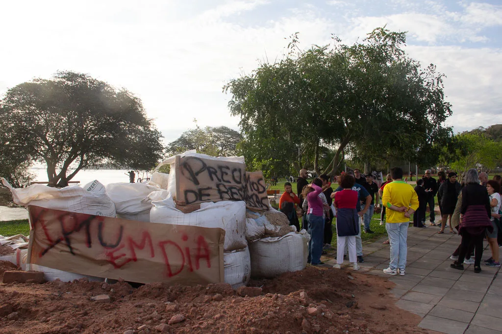 Com cartaz 'IPTU em dia, precisamos de respostas', moradores cobram proteção contra novas cheias no Guarujá