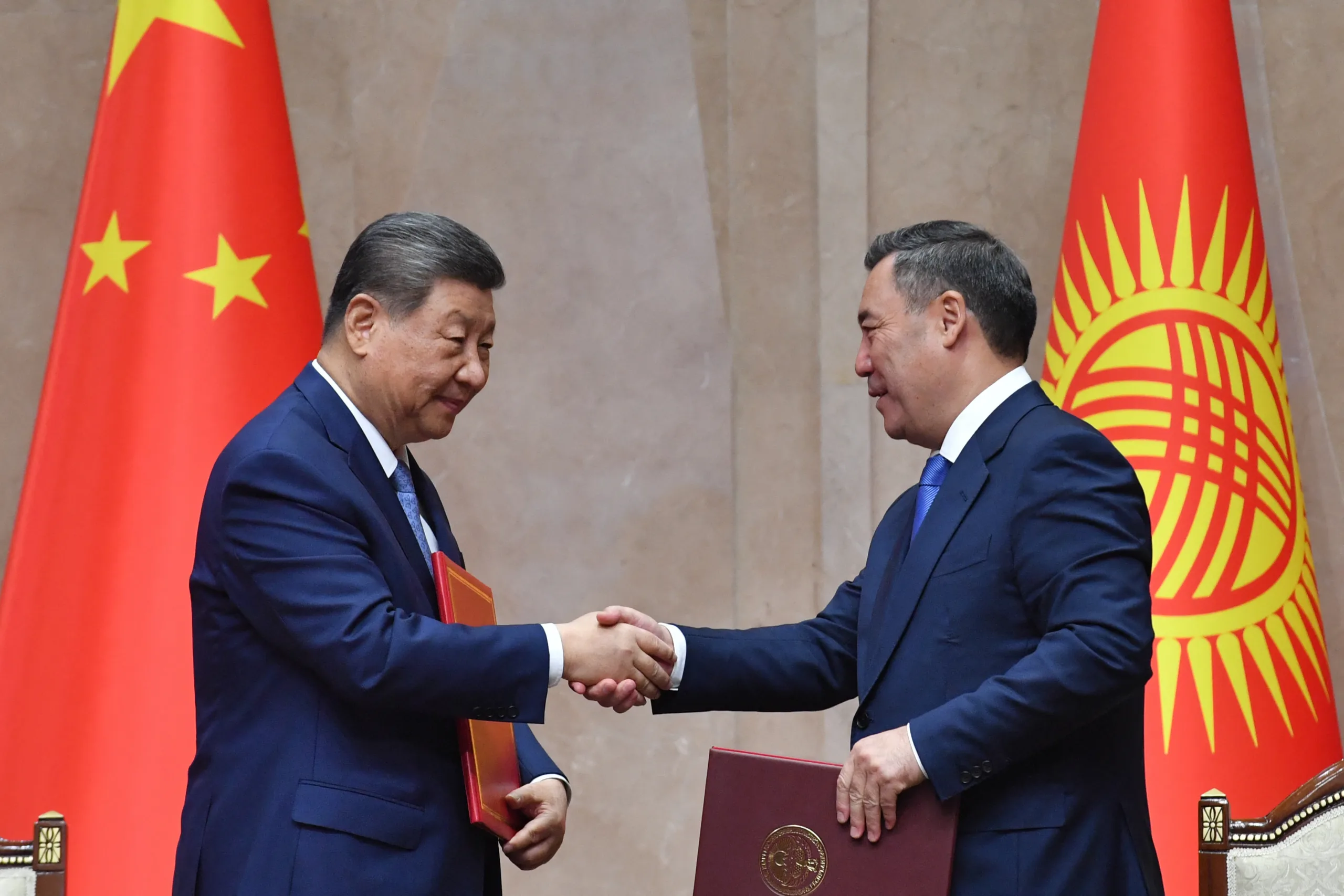 Presidente do Quirguistão, Sadyr Japarov, e presidente da China, Xi Jinping, se cumprimentam durante cerimônia de assinatura de atos em Bishkek, em 31 de agosto de 2026. Vyacheslav Oseledko / AFP